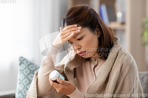 Image of sick asian woman with painkiller medicine at home