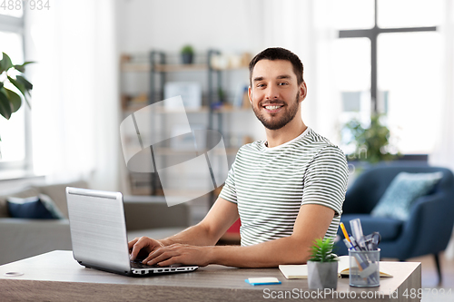 Image of man with laptop working at home office