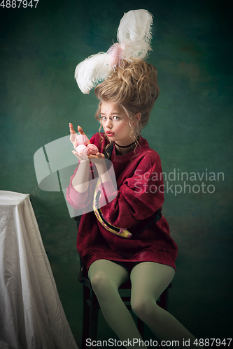 Image of Young woman as Marie Antoinette on dark background. Retro style, comparison of eras concept.