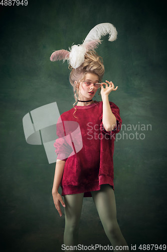 Image of Young woman as Marie Antoinette on dark background. Retro style, comparison of eras concept.