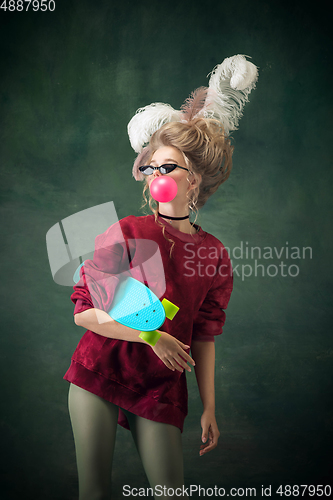 Image of Young woman as Marie Antoinette on dark background. Retro style, comparison of eras concept.