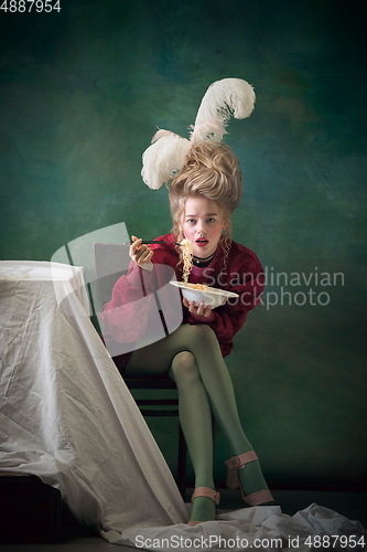 Image of Young woman as Marie Antoinette on dark background. Retro style, comparison of eras concept.