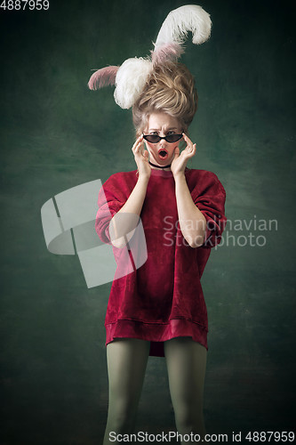 Image of Young woman as Marie Antoinette on dark background. Retro style, comparison of eras concept.