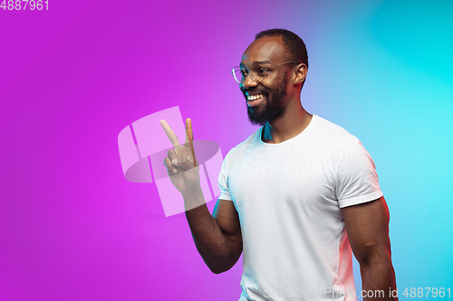 Image of African-american young man\'s portrait on gradient studio background in neon