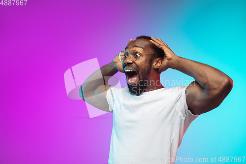 Image of African-american young man\'s portrait on gradient studio background in neon