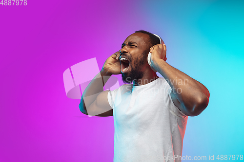 Image of African-american young man\'s portrait on gradient studio background in neon