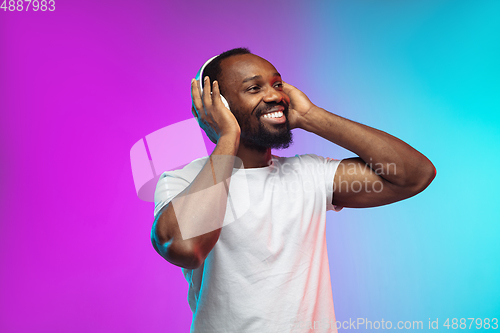 Image of African-american young man\'s portrait on gradient studio background in neon