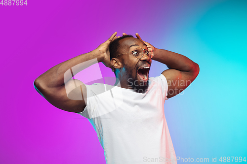 Image of African-american young man\'s portrait on gradient studio background in neon