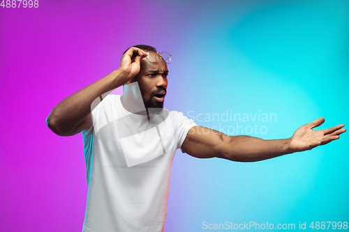 Image of African-american young man\'s portrait on gradient studio background in neon