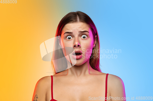 Image of Caucasian young woman\'s portrait on gradient studio background in neon