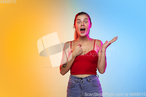 Image of Caucasian young woman\'s portrait on gradient studio background in neon