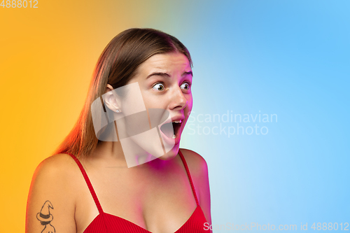 Image of Caucasian young woman\'s portrait on gradient studio background in neon