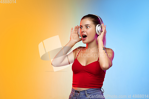Image of Caucasian young woman\'s portrait on gradient studio background in neon