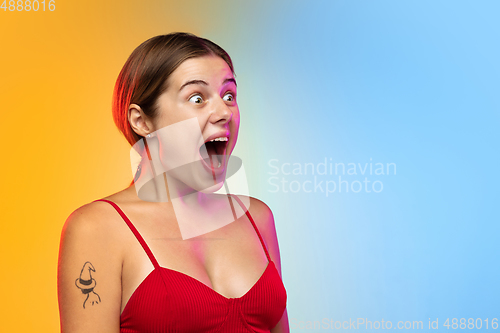 Image of Caucasian young woman\'s portrait on gradient studio background in neon