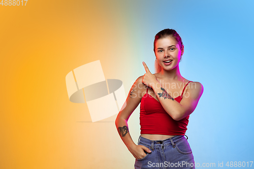 Image of Caucasian young woman\'s portrait on gradient studio background in neon