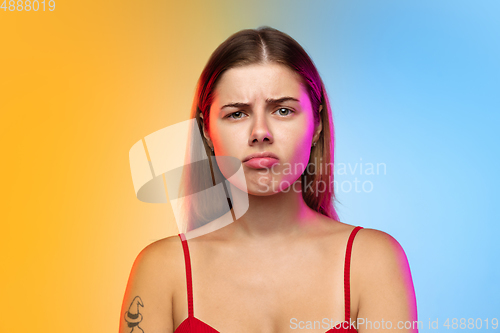 Image of Caucasian young woman\'s portrait on gradient studio background in neon