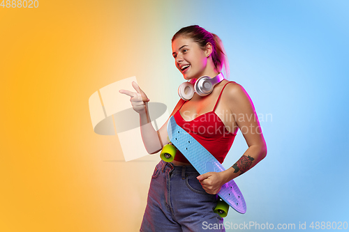 Image of Caucasian young woman\'s portrait on gradient studio background in neon