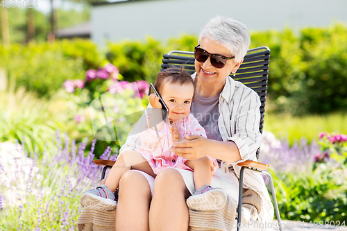 Image of grandmother and baby granddaughter with smartphone