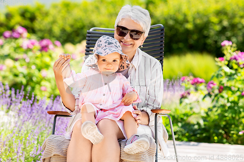 Image of happy grandmother and baby granddaughter at garden