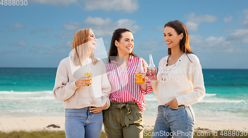 Image of young women with non alcoholic drinks on beach