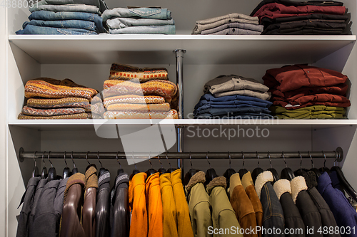 Image of clothes on shelves and hanger at clothing store