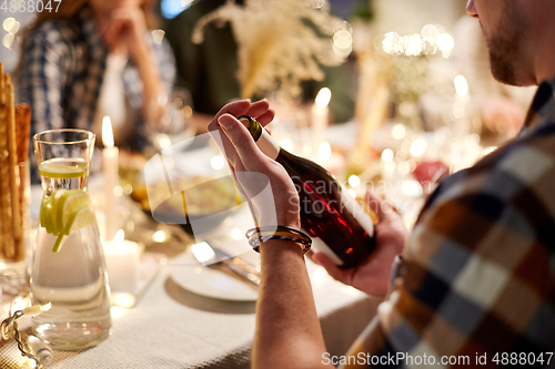 Image of happy friends with red wine at christmas party