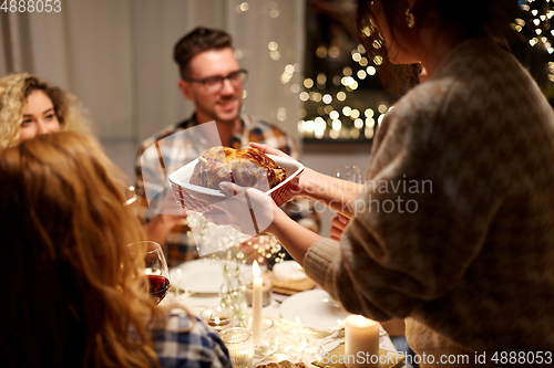 Image of happy friends having christmas dinner at home