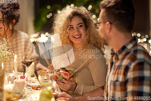 Image of happy friends having christmas dinner at home