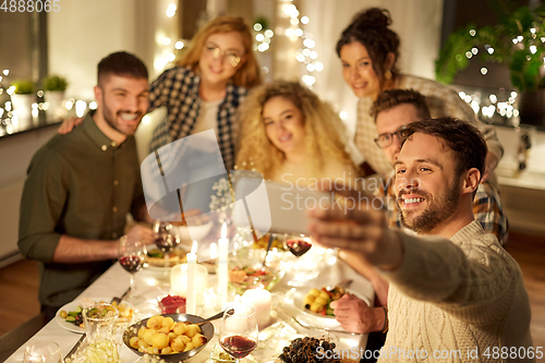Image of friends taking selfie at christmas dinner party