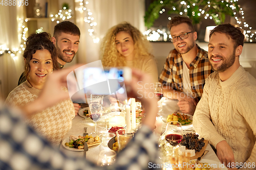 Image of friends photographing at christmas dinner party