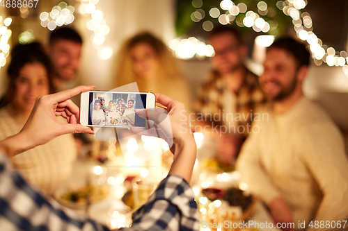 Image of friends photographing at christmas dinner party