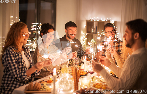 Image of happy friends having christmas dinner at home