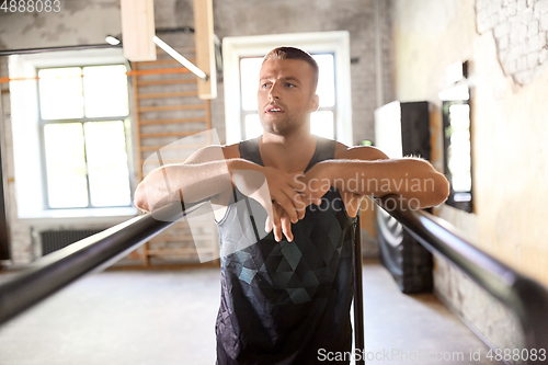 Image of young man at parallel bars in gym