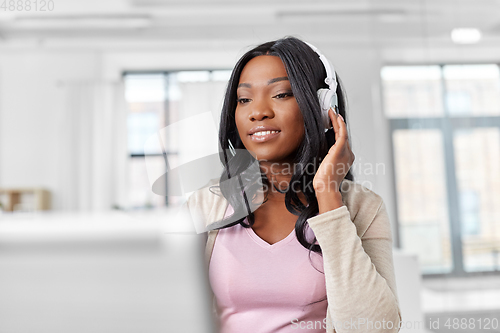 Image of woman in headphones with laptop working at home