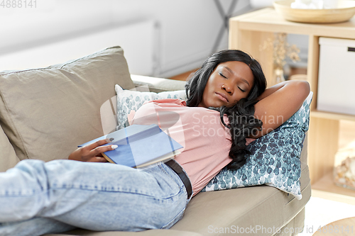Image of african american woman sleeping on sofa at home