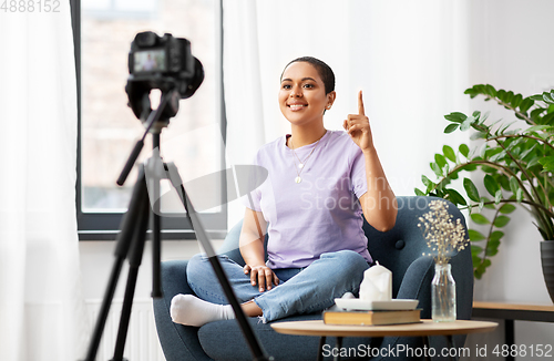 Image of female blogger with camera video blogging at home