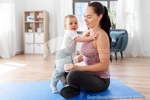 Image of happy mother with little baby at home