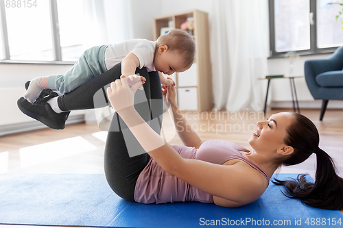 Image of happy mother with little baby exercising at home