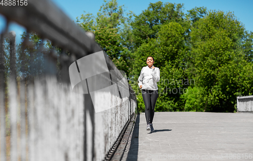 Image of african american woman running outdoors