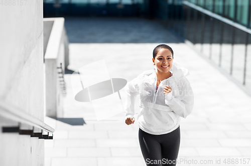 Image of african american woman running upstairs outdoors