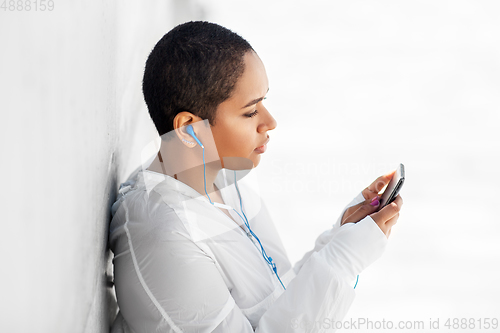 Image of african american woman with earphones and phone