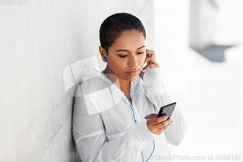 Image of african american woman with earphones and phone