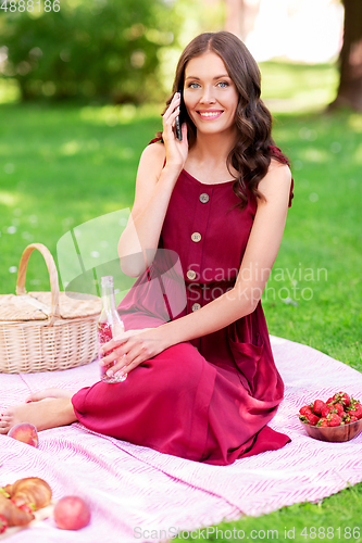 Image of woman calling on smartphone on picnic at park