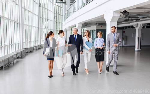 Image of business people walking along office building