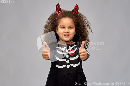 Image of girl in black dress and devil's horns on halloween