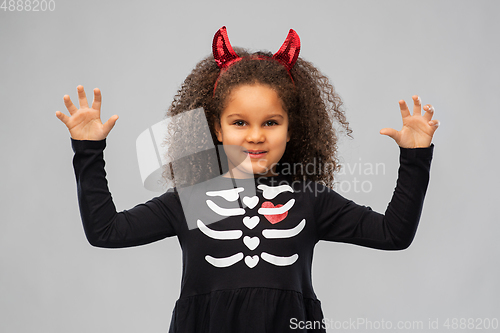 Image of girl in black dress and devil's horns on halloween