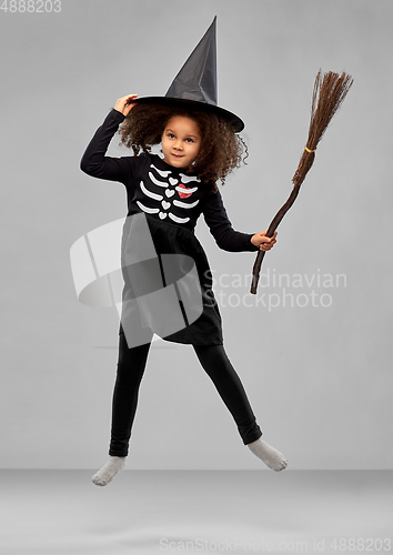 Image of girl in black witch hat with broom on halloween