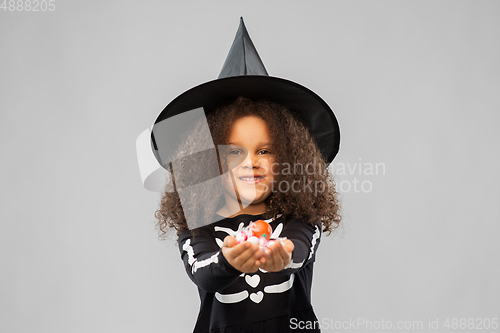 Image of girl with candies trick-or-treating on halloween