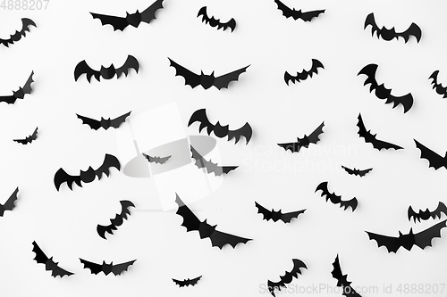 Image of flock of black paper bats over white background