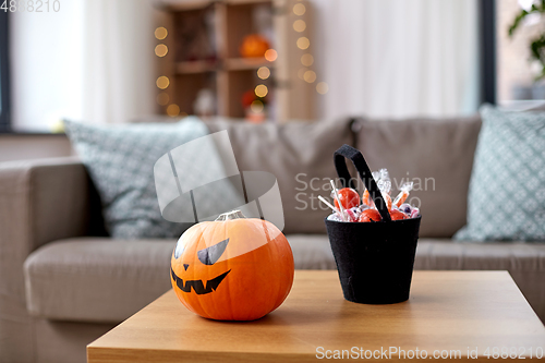Image of jack-o-lantern and candies at home on halloween